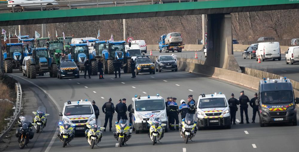 Poliser och traktorer på motorväg utanför Paris.